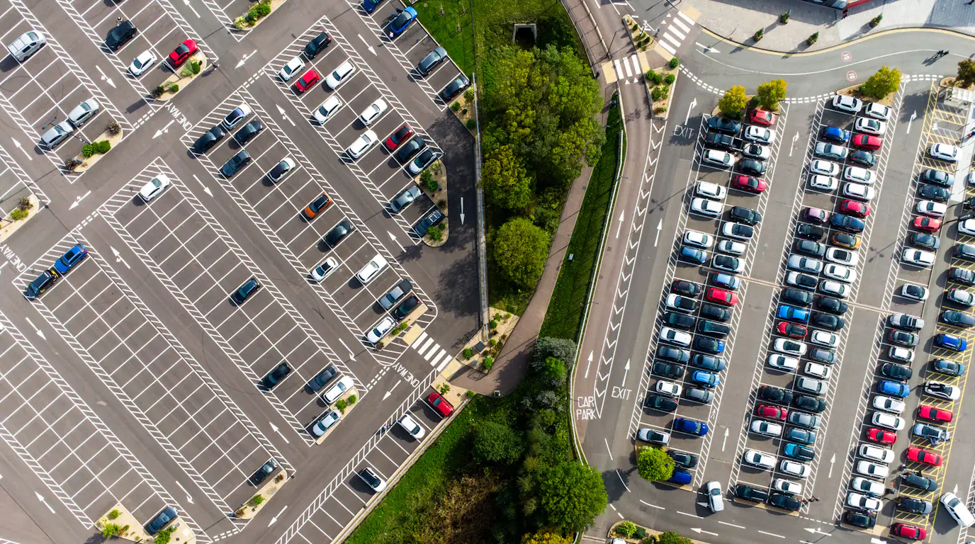 Aerial view of a parking lot with cars parked in it (2828x2121). Weak match: a commercial lot, but no EV chargers visible in the description