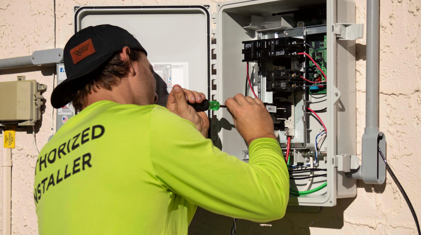 Technician using a screwdriver on an electrical panel